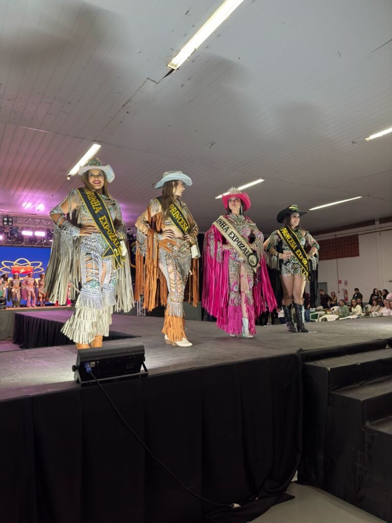 Baile da Rainha ExpoZal 2026 encanta o público com brilho, elegância e tradição em Sapezal No dia 06 de junho de 2026, Sapezal viveu um dos momentos mais aguardados da programação da ExpoZal: o tradicional Baile da Rainha ExpoZal 2026. O evento reuniu autoridades, patrocinadores, familiares e a comunidade para prestigiar um verdadeiro espetáculo de beleza, simpatia, desenvoltura e valorização da cultura sertaneja. Promovido pelo Lions Clube de Sapezal-MT, o baile foi marcado pela organização impecável e pela emoção que tomou conta do público durante os desfiles das candidatas. Com figurinos deslumbrantes, inspirados no universo country e repletos de brilho, franjas e detalhes sofisticados, as participantes transformaram a passarela em um show de elegância e personalidade. A Nova Corte da ExpoZal 2026 As candidatas demonstraram confiança, carisma e dedicação em cada apresentação, encantando os jurados e arrancando aplausos da plateia. Após desfiles de alto nível que evidenciaram o comprometimento e a beleza da mulher sapezalense, foram coroadas as grandes representantes da feira: • Rainha ExpoZal 2026: Destacando-se com um traje marcante em tom rosa vibrante e muito glamour. • Madrinha ExpoZal 2026: Encantando a passarela em um traje prata com detalhes impecáveis. • 1ª Princesa: Esbanjando simpatia em uma composição sofisticada em tons de caramelo. • 2ª Princesa: Fechando a corte oficial com muita elegância e brilho em seu traje escuro. Muito além da disputa pelos títulos, o baile celebrou a amizade, a integração e o espírito festivo que antecede uma das maiores festas do município. Tradição e Organização O Lions Clube de Sapezal, idealizador e promotor do evento, mais uma vez demonstrou seu compromisso com a valorização das tradições locais e com a realização de ações que fortalecem a cultura e o entretenimento da comunidade. O trabalho dedicado da entidade foi fundamental para proporcionar uma noite memorável, marcada pela emoção e pelo glamour. Com o sucesso do Baile da Rainha, cresce a expectativa para a programação da ExpoZal 2026, que promete reunir grandes atrações e movimentar a economia local, consolidando-se como um dos eventos mais importantes da região. O Baile da Rainha ExpoZal 2026 ficará na memória como uma celebração do talento, da beleza e da dedicação das candidatas, que abrilhantaram a noite e demonstraram o orgulho de representar Sapezal em uma das mais tradicionais festividades do município.