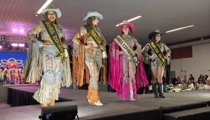 Baile da Rainha ExpoZal 2026 encanta o público com brilho, elegância e tradição em Sapezal No dia 06 de junho de 2026, Sapezal viveu um dos momentos mais aguardados da programação da ExpoZal: o tradicional Baile da Rainha ExpoZal 2026. O evento reuniu autoridades, patrocinadores, familiares e a comunidade para prestigiar um verdadeiro espetáculo de beleza, simpatia, desenvoltura e valorização da cultura sertaneja. Promovido pelo Lions Clube de Sapezal-MT, o baile foi marcado pela organização impecável e pela emoção que tomou conta do público durante os desfiles das candidatas. Com figurinos deslumbrantes, inspirados no universo country e repletos de brilho, franjas e detalhes sofisticados, as participantes transformaram a passarela em um show de elegância e personalidade. A Nova Corte da ExpoZal 2026 As candidatas demonstraram confiança, carisma e dedicação em cada apresentação, encantando os jurados e arrancando aplausos da plateia. Após desfiles de alto nível que evidenciaram o comprometimento e a beleza da mulher sapezalense, foram coroadas as grandes representantes da feira: • Rainha ExpoZal 2026: Destacando-se com um traje marcante em tom rosa vibrante e muito glamour. • Madrinha ExpoZal 2026: Encantando a passarela em um traje prata com detalhes impecáveis. • 1ª Princesa: Esbanjando simpatia em uma composição sofisticada em tons de caramelo. • 2ª Princesa: Fechando a corte oficial com muita elegância e brilho em seu traje escuro. Muito além da disputa pelos títulos, o baile celebrou a amizade, a integração e o espírito festivo que antecede uma das maiores festas do município. Tradição e Organização O Lions Clube de Sapezal, idealizador e promotor do evento, mais uma vez demonstrou seu compromisso com a valorização das tradições locais e com a realização de ações que fortalecem a cultura e o entretenimento da comunidade. O trabalho dedicado da entidade foi fundamental para proporcionar uma noite memorável, marcada pela emoção e pelo glamour. Com o sucesso do Baile da Rainha, cresce a expectativa para a programação da ExpoZal 2026, que promete reunir grandes atrações e movimentar a economia local, consolidando-se como um dos eventos mais importantes da região. O Baile da Rainha ExpoZal 2026 ficará na memória como uma celebração do talento, da beleza e da dedicação das candidatas, que abrilhantaram a noite e demonstraram o orgulho de representar Sapezal em uma das mais tradicionais festividades do município.